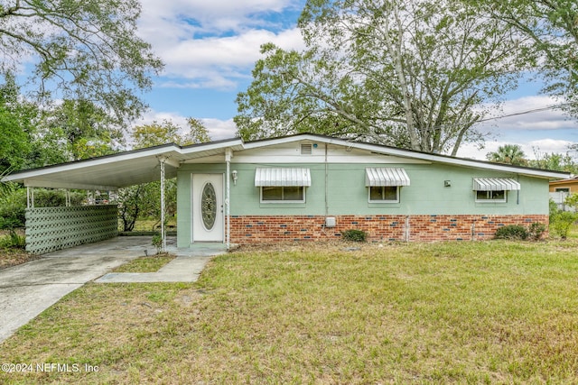 ranch-style house featuring a carport and a front lawn