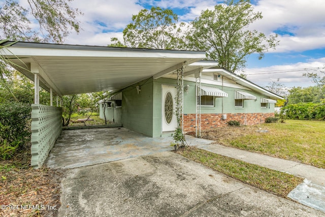 view of vehicle parking with a lawn and a carport