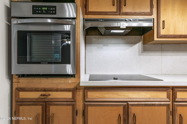 kitchen featuring extractor fan, black electric stovetop, and stainless steel oven