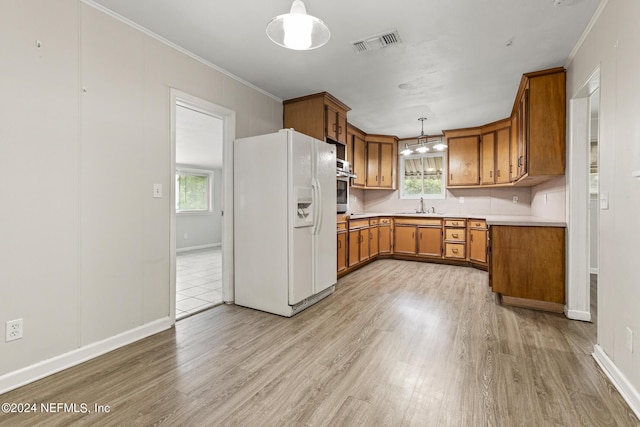 kitchen with oven, hanging light fixtures, white fridge with ice dispenser, crown molding, and light wood-type flooring