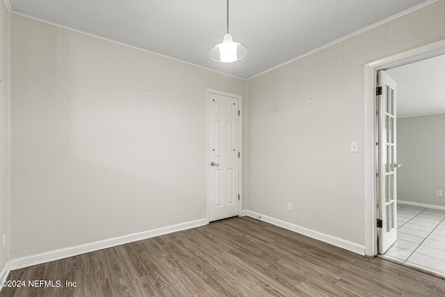 empty room with hardwood / wood-style flooring and crown molding