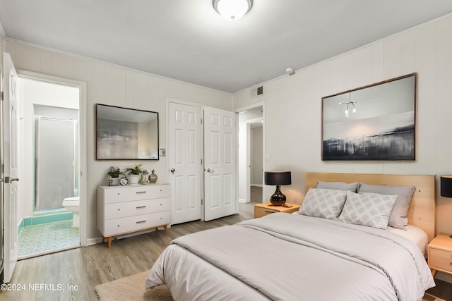 bedroom with ornamental molding, light hardwood / wood-style floors, and ensuite bathroom