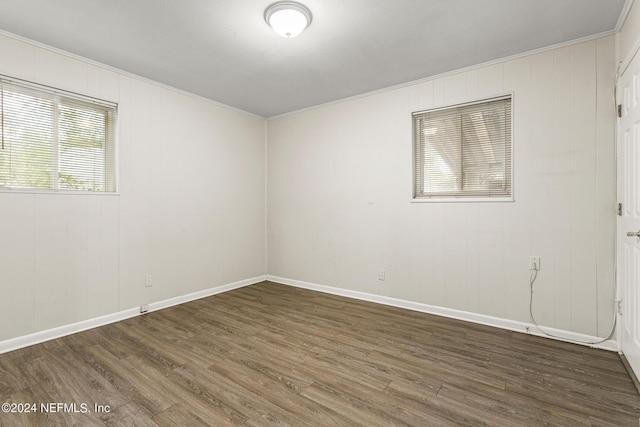 unfurnished room featuring ornamental molding and dark wood-type flooring