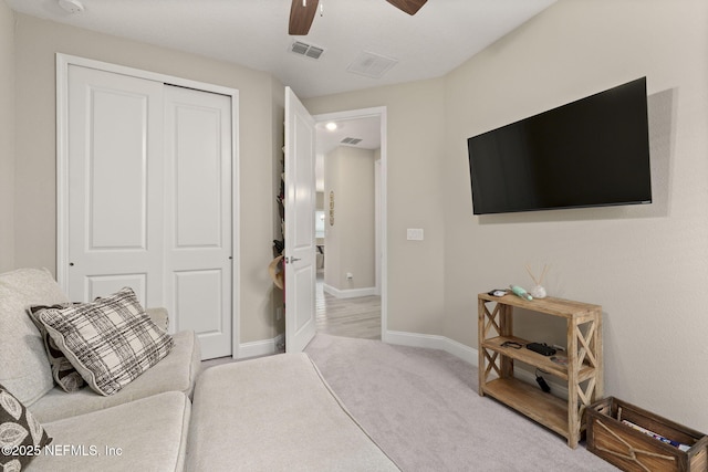 interior space featuring light carpet and ceiling fan