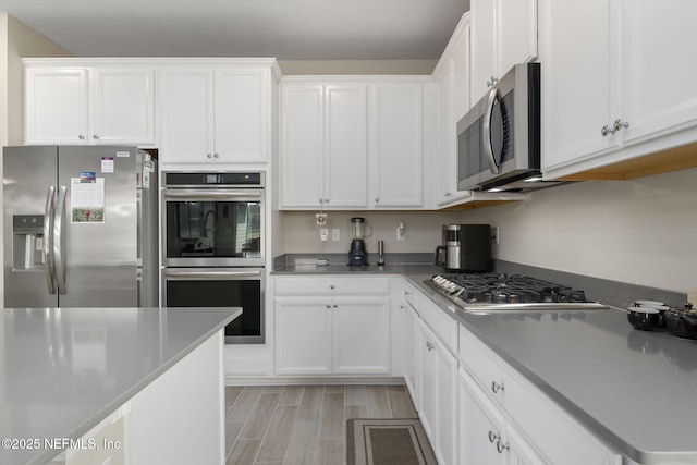 kitchen with white cabinetry, appliances with stainless steel finishes, and light wood-type flooring