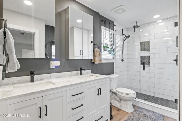 bathroom with hardwood / wood-style flooring, vanity, toilet, and an enclosed shower