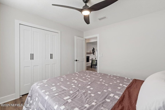 bedroom with ceiling fan, dark hardwood / wood-style flooring, and a closet