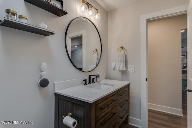 bathroom featuring hardwood / wood-style flooring, vanity, and a textured ceiling