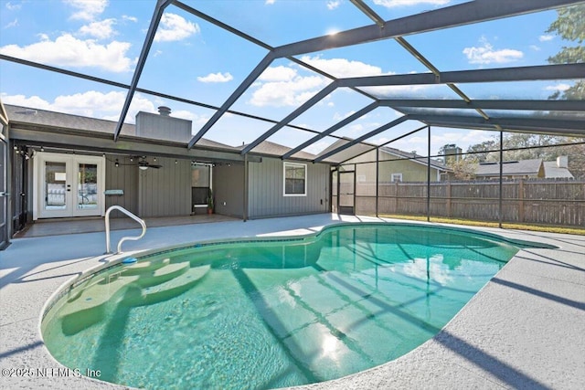 view of swimming pool featuring a lanai, a patio area, and french doors