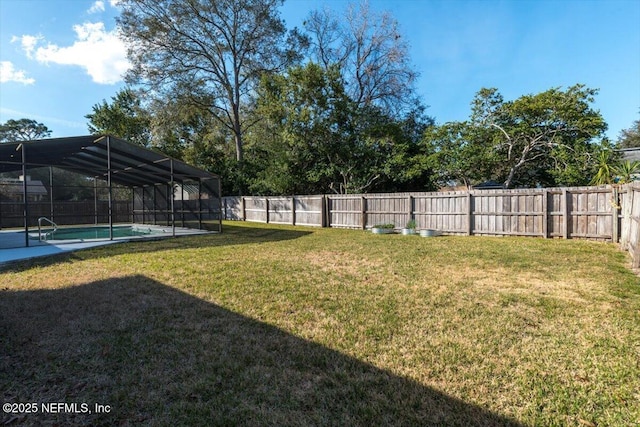 view of yard with a lanai and a fenced in pool