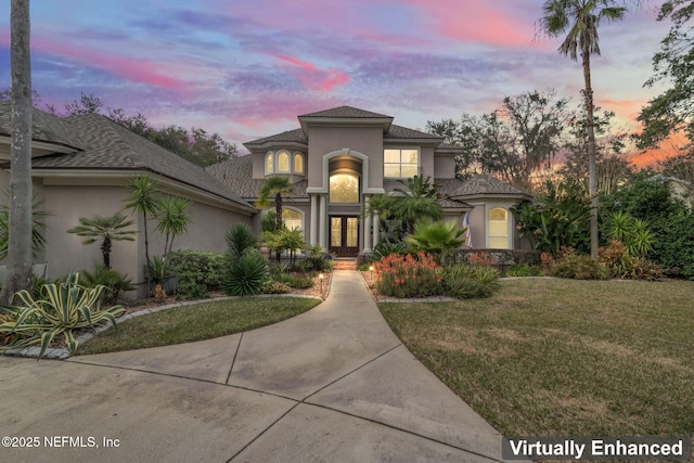 mediterranean / spanish-style home featuring french doors and a lawn