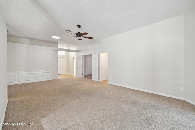 carpeted spare room featuring ceiling fan and a textured ceiling