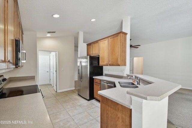 kitchen featuring lofted ceiling, sink, kitchen peninsula, ceiling fan, and stainless steel appliances