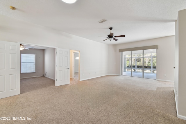 carpeted empty room with ceiling fan and a textured ceiling