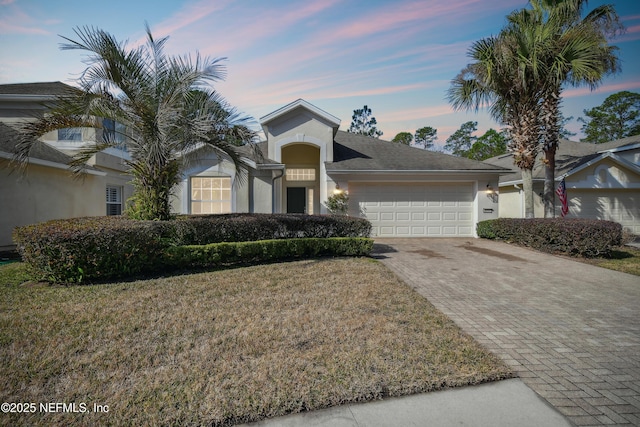 view of front facade with a garage and a yard