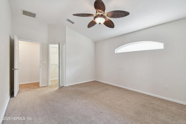 unfurnished bedroom featuring ceiling fan, a spacious closet, light carpet, and a textured ceiling