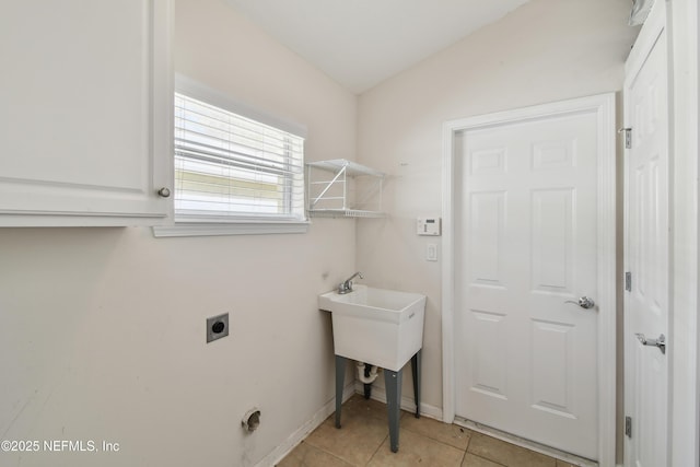 laundry room featuring electric dryer hookup and light tile patterned floors