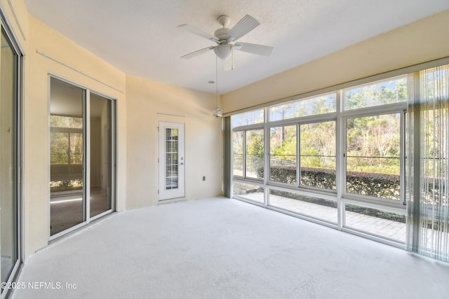 unfurnished sunroom featuring ceiling fan