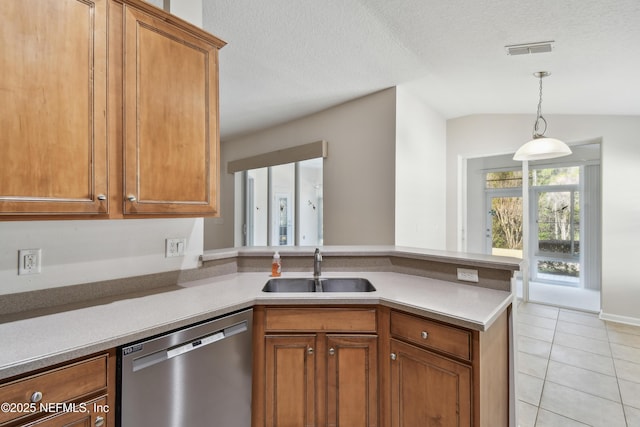 kitchen featuring sink, light tile patterned floors, vaulted ceiling, stainless steel dishwasher, and kitchen peninsula