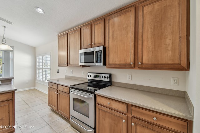 kitchen featuring pendant lighting, lofted ceiling, stainless steel appliances, a textured ceiling, and light tile patterned flooring