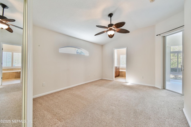 unfurnished room with vaulted ceiling, light carpet, a textured ceiling, and ceiling fan