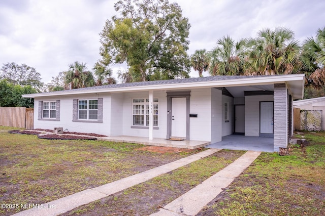 single story home featuring a front yard and a carport