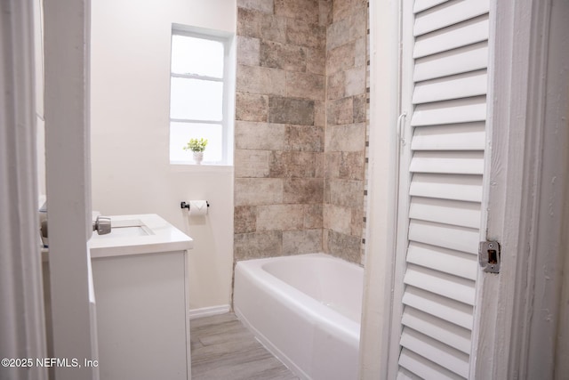 bathroom with vanity, hardwood / wood-style floors, and tiled shower / bath combo