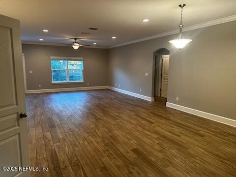 spare room with dark hardwood / wood-style floors, ceiling fan, and ornamental molding