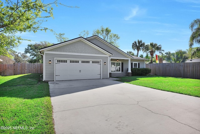 view of front of property featuring a front lawn, an attached garage, driveway, and fence