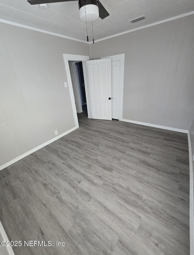 unfurnished room featuring crown molding, wood-type flooring, and ceiling fan