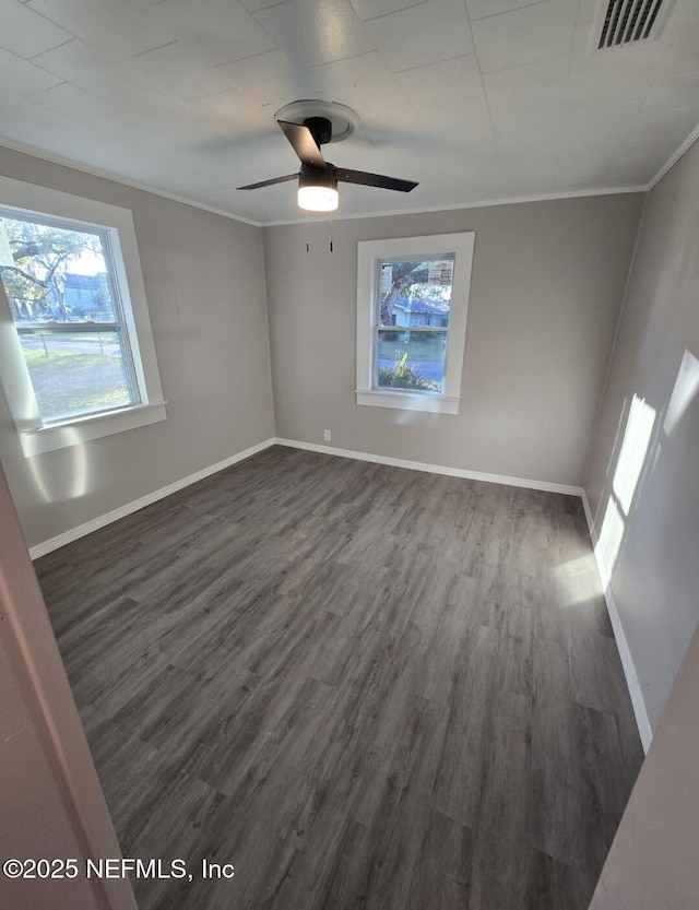 empty room featuring crown molding, dark wood-type flooring, and ceiling fan