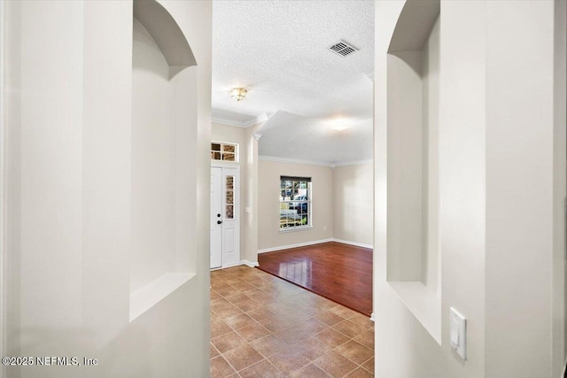 hall featuring a textured ceiling and crown molding