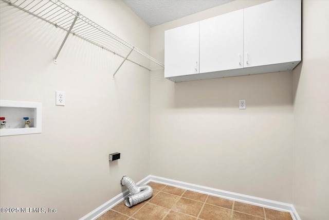 laundry room featuring washer hookup, cabinets, and a textured ceiling