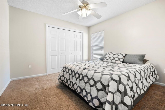 bedroom featuring ceiling fan, dark colored carpet, a textured ceiling, and a closet