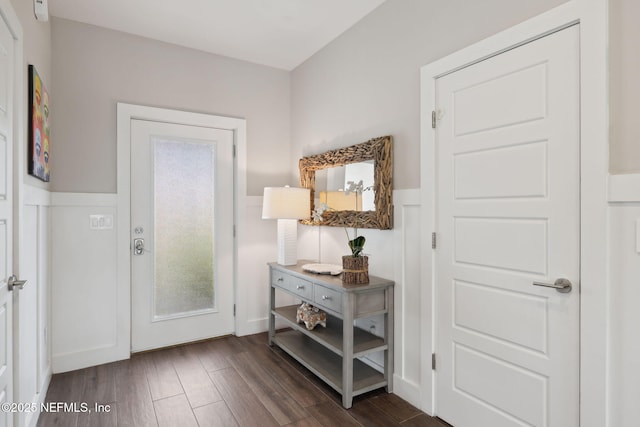 entryway with a wainscoted wall, a decorative wall, and dark wood-style flooring