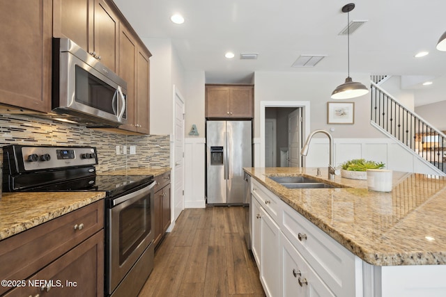 kitchen featuring dark wood-style flooring, a sink, visible vents, appliances with stainless steel finishes, and tasteful backsplash