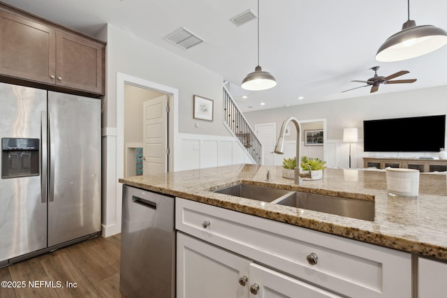 kitchen with stainless steel appliances, dark wood-type flooring, a sink, and visible vents