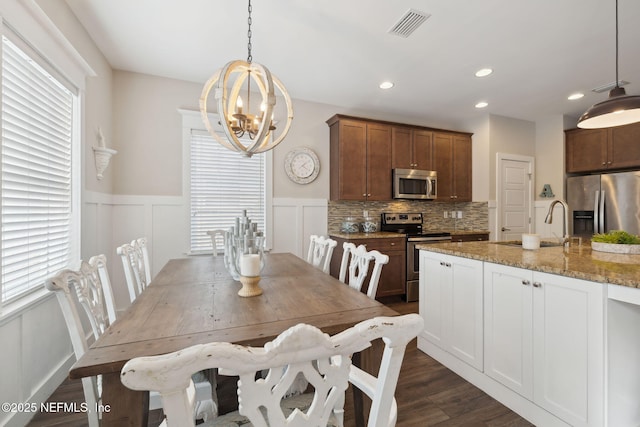 dining room with a decorative wall, recessed lighting, a notable chandelier, dark wood-style flooring, and visible vents