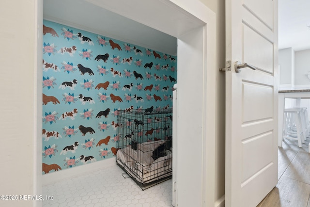 bathroom with wallpapered walls and baseboards