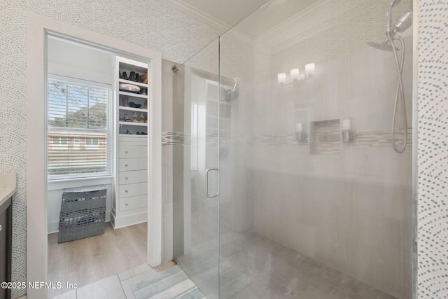 full bathroom featuring ornamental molding, a shower stall, vanity, wood finished floors, and wallpapered walls