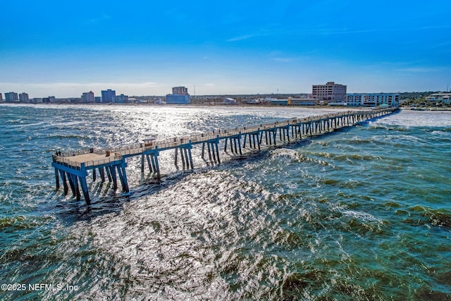 view of dock featuring a view of city, a pier, and a water view