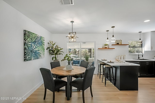 dining space with light hardwood / wood-style flooring and sink