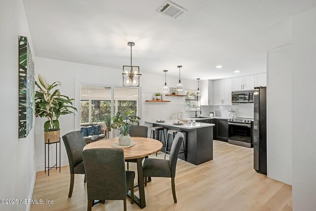 dining space featuring light hardwood / wood-style flooring and sink