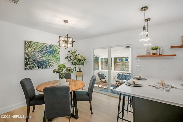 dining room featuring light hardwood / wood-style floors and a chandelier