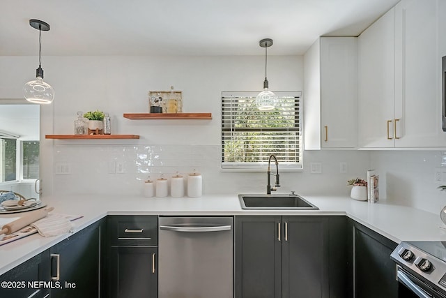 kitchen featuring sink, stainless steel appliances, pendant lighting, and white cabinets
