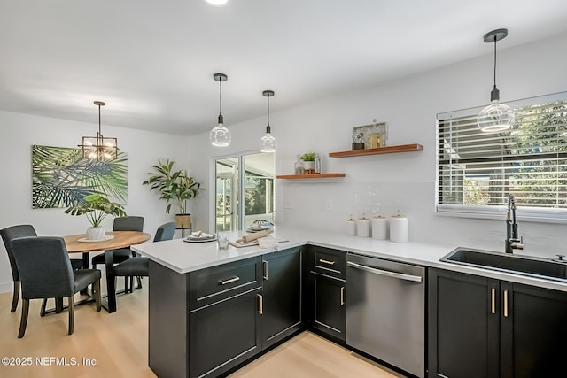 kitchen featuring hanging light fixtures, sink, stainless steel dishwasher, and kitchen peninsula