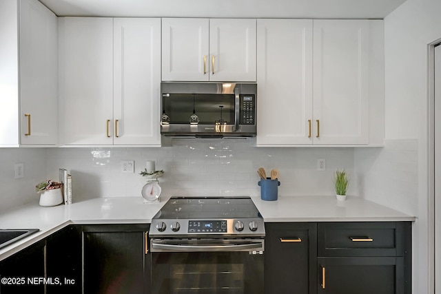kitchen with appliances with stainless steel finishes, white cabinetry, and tasteful backsplash