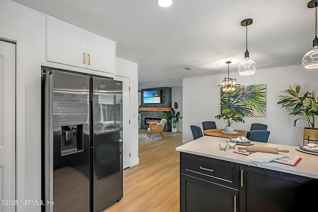 kitchen featuring light hardwood / wood-style flooring, pendant lighting, white cabinetry, and stainless steel fridge with ice dispenser
