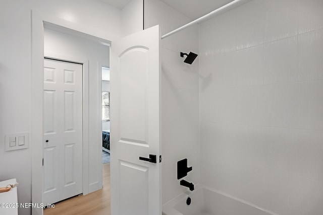 bathroom featuring tiled shower / bath and wood-type flooring