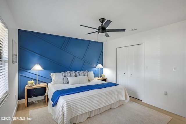 bedroom with ceiling fan, light hardwood / wood-style flooring, and a closet